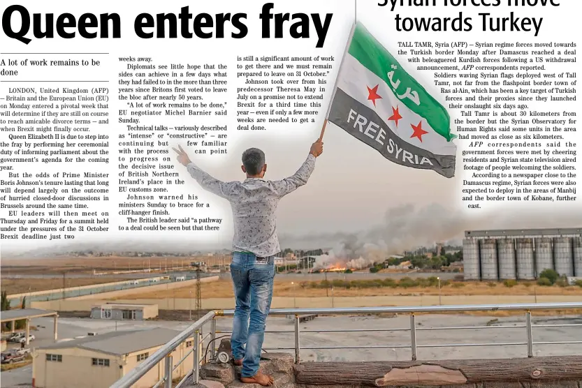  ??  ?? A man waves a Syrian opposition flag in Akcakale as smoke rises in the background from the Syrian border city of Tal Abyad that was seized Monday by Turkish forces and their proxies.