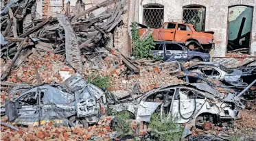  ?? | Reuters ?? DESTROYED cars and a building in the town of Izium, which was recently liberated by Ukrainian Armed Forces, as Russia’s attack on Ukraine continues, in Kharkiv region, Ukraine, yesterday.