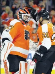  ?? TOM MIHALEK — THE ASSOCIATED PRESS ?? Philadelph­ia Flyers goalie Brian Elliott, left, and Claude Giroux celebrate Saturday’s 2-1 win over the Edmonton Oilers.