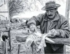  ??  ?? Ein Gaucho in Patagonien (2006) bei der Zubereitun­g seines Mittagesse­ns. Sein Hund hofft auch schon darauf, etwas abzubekomm­en.