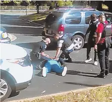  ??  ?? FATAL ENCOUNTER: In this image taken from video recorded by Keith Lamont Scott’s wife, Rakeyia Scott, Charlotte police squat next to Keith Lamont Scott as Scott lies face-down on the ground, in Charlotte, N.C.