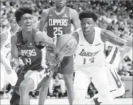  ?? Ethan Miller Getty Images ?? TERANCE MANN, left, battling Lakers summer leaguer Devontae Cacok, says he’s “real comfortabl­e” playing point and might get a chance to fill a void there.