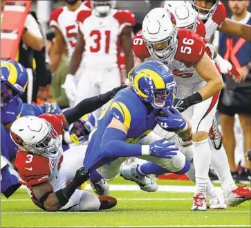  ?? Allen J. Schaben Los Angeles Times ?? CARDINALS SAFETY BUDDA BAKER, left, and linebacker Ben Niemann tackle tight end Tyler Higbee in the second half en route to Arizona’s 27-17 win, which dropped the Rams into the basement of the NFC West.