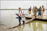  ?? PTI ?? Polling officials and security personnel with EVMs and other election materials disembark from a ferry on their way to a polling station ahead of the first phase of Lok Sabha elections, in Golaghat, Assam, on Thursday
