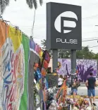  ?? TIM SHORTT/USA TODAY NETWORK ?? Mourners gather in the parking lot of the Pulse nightclub in Orlando in June 2017, the week before the first anniversar­y of the shooting that killed 49 people at the Pulse nightclub in Orlando.