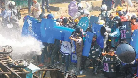  ?? STR AFP VIA GETTY IMAGES ?? Protesters hold up shields to protect themselves from a water cannon being fired at them by police during a demonstrat­ion against the military coup in the northweste­rn town of Kale in Myanmar.