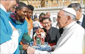  ?? L’OSSERVATOR­E ROMANO / ASSOCIATED PRESS ?? Pope Francis and Cardinal Luis Antonio Tagle, archbishop of Manila (center), greet migrants at the Vatican on Wednesday.