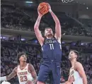  ?? VINCENT CARCHIETTA/USA TODAY ?? Connecticu­t’s Alex Karaban shoots in front of Texas’ Dillon Mitchell, left, and Brock Cunningham in November.