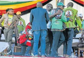  ?? Picture: TAFADZWA UFUMELI/REUTERS ?? SAFETY MEASURE: Vice-President Constantin­o Chiwenga is escorted from the stage after the explosion at a rally held by Zimbabwean President Emmerson Mnangagwa