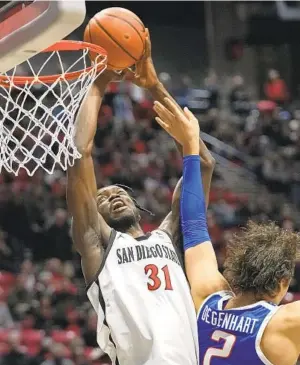  ?? GREGORY BULL AP ?? Aztecs big man Nathan Mensah shoots as Boise State forward Tyson Degenhart tries to defend in the first half Friday. Mensah drew 10 fouls on Boise State players, four on Degenhart.