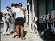  ?? JOHN MINCHILLO — THE ASSOCIATED PRESS ?? Family members of slain mass shooting victim Thomas “TJ” McNichols, from left, Donna Johnson, aunt, and sisters Jamila and Finesse McNichols, mourn beside a memorial near the scene of the shooting Monday in Dayton, Ohio.