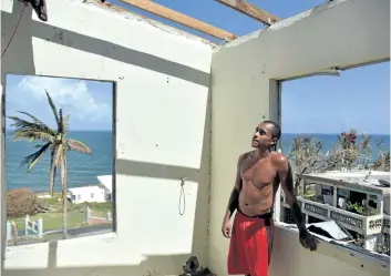  ?? HECTOR RETAMAL/GETTY IMAGES ?? A man looks at damage to his house in Yabucoa, in the east of Puerto Rico, on Thursday. The U.S. island territory is struggling to dig out and clean up from its disastrous brush with hurricane Maria.