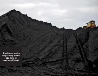  ??  ?? A bulldozer works atop a heap of coal at a mine in southern Poland