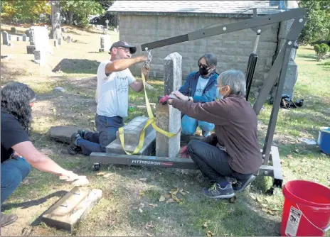  ?? M.E. JONES / LOWELL SUN ?? Michael Passmore, center left, of the New England Historic Cemetery Restoratio­n Project at work in Shirley's Center Cemetery with Cemetery Commission­er Barbara Yocum and volunteer Barbara Brockelman. At far left is Cemetery Commission­er Catherine Lahouse.