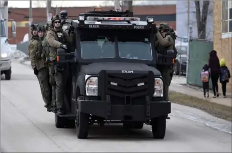  ?? MATT MARTON — THE ASSOCIATED PRESS ?? Police officers ride on an armored vehicle Friday near the site of a mass shooting at a manufactur­ing plant in Aurora, Ill.