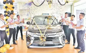  ??  ?? MITSUBISHI OUTLANDER: Sim (dua kiri) bersama wakil jualan Jimisar Autotrade Sdn Bhd pada pelancaran Mitsubishi Outlander SUV 2.0L di bilik pameran di Persiaran Brooke.