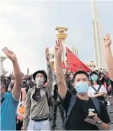  ??  ?? RIGHT Many flash a three-finger salute as they surround Democracy Monument before setting off for Government House.