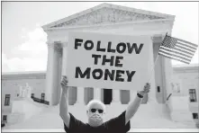  ?? [ANDREW HARNIK/ THE ASSOCIATED PRESS] ?? Bill Christeson holds up a sign that reads “Follow the Money” on Thursday outside the Supreme Court in Washington.