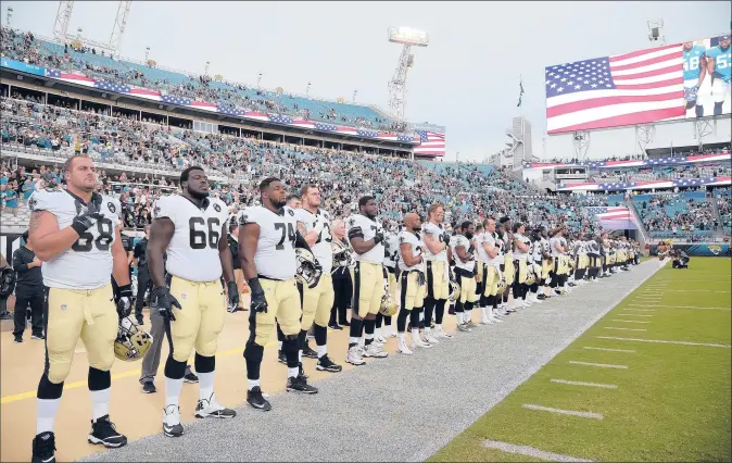  ?? PHELAN M. EBENHACK | AP ?? THE MEMBERS OF the New Orleans Saints stand in unison for the singing of the national anthem before an NFL preseason game at Jacksonvil­le, Fla., in August. As the 2018 season begins, the league and players have been unable to come to an agreeable solution to the controvers­ial issue.