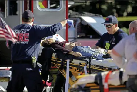  ?? JOHN MCCALL — SOUTH FLORIDA SUN-SENTINEL VIA AP ?? Medical personnel tend to a victim following a shooting at Marjory Stoneman Douglas High School in Parkland, Fla., on Wednesday.