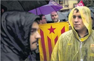  ?? AP PHOTO ?? Protesters, one of them holding a pro-independen­ce flag, gather at the gates of the Spanish central government offices in Barcelona Thursday.