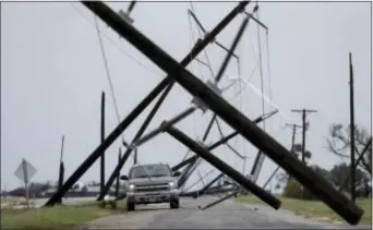  ?? ASSOCIATED PRESS ?? A driver works his way through a maze of fallen utility poles damaged in the wake of Hurricane Harvey, Saturday, in Taft, Texas.