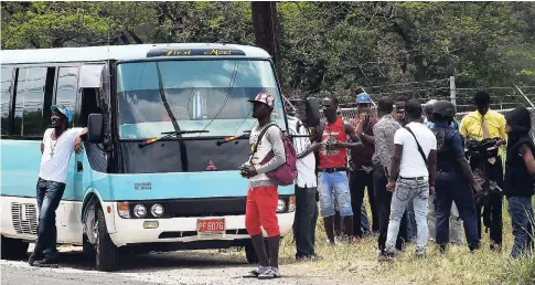  ?? FILE ?? Police search passengers at a checkpoint in the St Catherine North Police Division where there is an ongoing state of emergency.