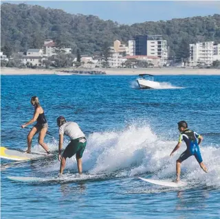  ??  ?? Boats, surfers and paddleboar­ders all share the Currumbin River mouth.