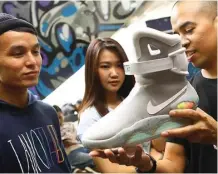  ?? DIPTA WAHYU/JAWA POS ?? EDISI TERBATAS: John Pelenkahu (kiri) melihat sepatunya, Nike Mag seri Back to the Future, sedang di-review Anugrah Aditya.