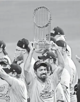  ??  ?? Anthony Rendon hoists the Commission­er’ s Trophy after beating the Astros. “Winning a World Series in your hometown, I don’t think you can plan that,” he says.