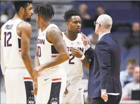  ?? Jessica Hill / Associated Press ?? UConn coach Dan Hurley, right, speaks with Tarin Smith (2) during a timeout in a game earlier this season. The Huskies return to action on Saturday against Manhattan.