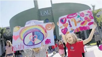  ?? JOE CAVARETTA/STAFF PHOTOGRAPH­ER ?? Preschool students Aiza Hussain, left, and Ava Rinne, both age 5, from Florida Atlantic University’s Karen Slattery Educationa­l Research Center for Child Developmen­t, hold signs during the Kindness and Peace Rally on Wednesday.