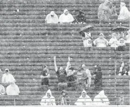  ?? BRIAN CASSELLA/CHICAGO TRIBUNE ?? The ground crew rolls out the tarp, top, as Sox fans sit in the rain during a delay Saturday before the game against the Mariners was suspended.