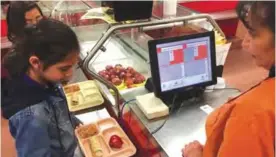  ??  ?? SANTA FE, New Mexico: Photo shows third grader Elliana Vigil punches in his student identifica­tion meal to pay for a meal at Gonzales Community School in Santa Fe. —AP photos