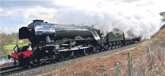  ?? Pictures: PA. ?? Flying Scotsman at full steam on her journey and, below, the locomotive pulls out of King’s Cross Station.