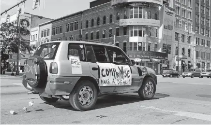  ??  ?? An SUV urges Congress to compromise on a COVID-19 relief package during a caravan rally around the Statehouse on Thursday.