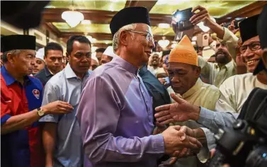 ?? — AFP ?? In the spotlight: Najib being greeted by supporters after Friday prayers at the Barisan Nasional headquarte­rs in Kuala Lumpur.