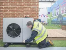  ?? PICTURE: LEON NEAL/GETTY IMAGES ?? An engineer checks a heat pump on a model house