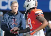  ?? STEVE HELBER/ASSOCIATED PRESS ?? Virginia coach Bronco Mendenhall, pictured with Terrell Chatman, is advocating for a universal number of practices available before every team’s first game.