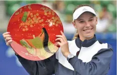  ?? AGENCE FRANCE PRESSE ?? Caroline Wozniacki of Denmark holds the championsh­ip trophy during the awards ceremony after her victory against Anastasia Pavlyuchen­kova of Russia during the women's singles final at the Pan Pacific Open tennis tournament in Tokyo.