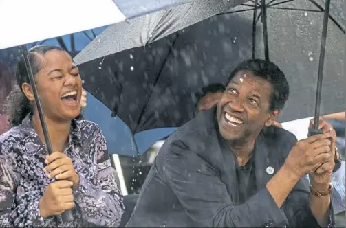  ?? Steph Chambers/Post-Gazette ?? Jamaica Johnson, an 11th-grader at Pittsburgh CAPA, and Denzel Washington share a moment during a “ground blessing” at the August Wilson House on Wednesday. Jamaica performed a monologue from Mr. Wilson’s “King Hedley II” at the ceremony.