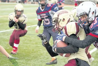  ?? JASON BAIN/ EXAMINER ?? Thomas A. Stewart's Adam Gilmour takes down a Huron Heights player near the sideline as the Griffons hosted the Warriors in the Metro Bowl junior play-in game at TASSS on Wednesday. TASSS won 22-21 in overtime to advance to the quarter-finals. See more...