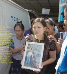  ?? — AFP ?? Su Thet Khine holds a photograph of her husband Ne Win, who was shot dead outside Yangon airport while trying to stop the gunman who assassinat­ed Muslim lawyer Ko Ni, at his funeral in Yangon on Tuesday.