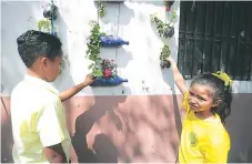  ??  ?? Unas coloridas maceteras colgantes elaboradas por la familia educativa adornan el Club Rotario Sur número dos.