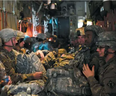  ?? PHOTO AFP ?? Des militaires de la 541e compagnie des sapeurs qui doivent être déployés le long de la frontière avec le Mexique attendent le décollage sur une piste de la base de Fort Knox.