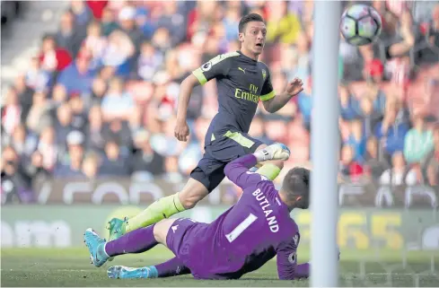  ?? AP ?? Arsenal’s Mesut Oezil scores his side’s second goal against Stoke City.