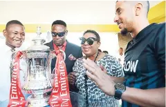  ?? RUDOLPH BROWN/PHOTOGRAPH­ER ?? With the FA Cup trophy being the focal point, FLOW’s sponsorshi­p and events manager, Stephen Miller (right), shares the spotlight with Sports Minister Olivia Grange (second right) and Charlie Smith’s football coach, Jerome Waite (second left); and the...