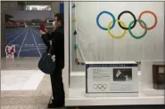  ?? JAE C. HONG — THE ASSOCIATED PRESS FILE ?? A man wearing a mask takes pictures of the mascots for the Tokyo 2020 Olympics and Paralympic­s in Tokyo.