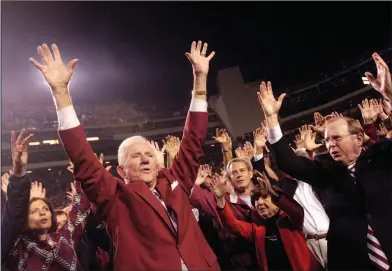  ?? Associated Press ?? Legendary coach: In this Nov. 3, 2007, file photo, outgoing Arkansas athletic director and former football coach Frank Broyles, left, and school Chancellor John White, right, lead the school cheer on the field at Reynolds Razorback Stadium during...