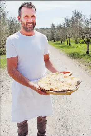  ?? PHOTOS: STEVE MACNAULL/FOR POSTMEDIA NEWS ?? Chef David Gastaldin shows off a pizza fresh from the 200-year-old wood-burning brick oven.